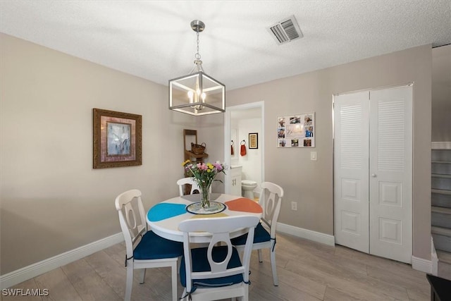 5249 Cedarbend Dr Unit 2, Fort Myers, FL 33919 - dining space with a chandelier, light wood-style floors, and baseboards