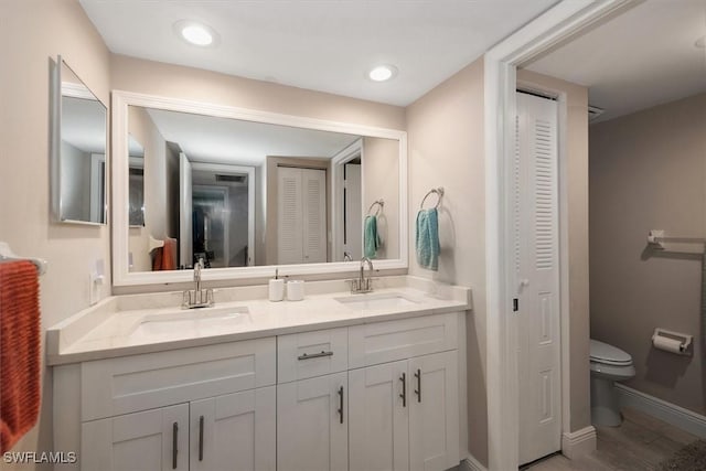 5249 Cedarbend Dr Unit 2, Fort Myers, FL 33919 - bathroom with a closet, double vanity, toilet, and baseboards