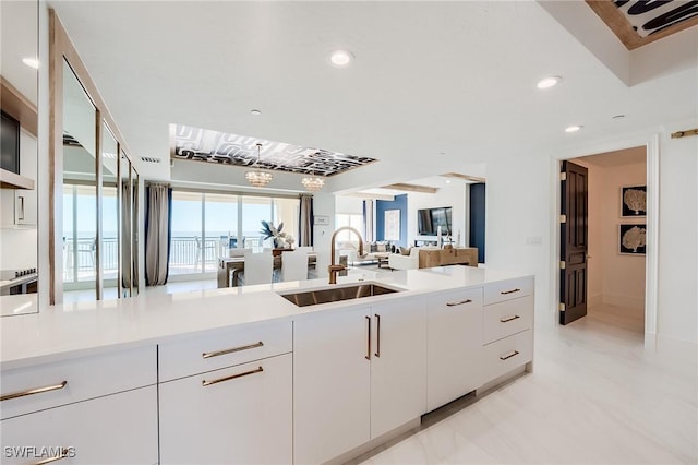 350 S Collier Blvd Unit 1103, Marco Island, FL 34145 - kitchen with a sink, open floor plan, light countertops, white cabinetry, and recessed lighting