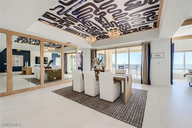 350 S Collier Blvd Unit 1103, Marco Island, FL 34145 - dining space with a tray ceiling and a water view
