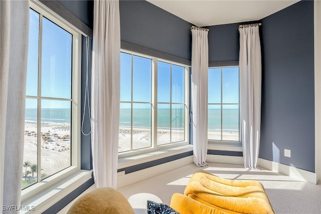 350 S Collier Blvd Unit 1103, Marco Island, FL 34145 - carpeted living area with healthy amount of natural light, view of water and beach, and baseboards