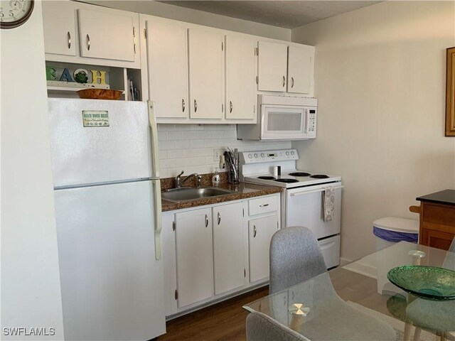 7360 Estero Blvd Unit 1102, Fort Myers Beach, FL 33931 - kitchen with white appliances, decorative backsplash, white cabinetry, dark countertops, and dark wood-type flooring