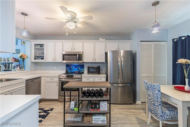 164 Belina Dr E Unit 4, Naples, FL 34104 - kitchen featuring stainless steel appliances, light countertops, white cabinetry, and decorative light fixtures