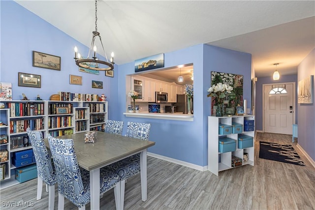 164 Belina Dr E Unit 4, Naples, FL 34104 - dining area with wood finished floors, a chandelier, and vaulted ceiling