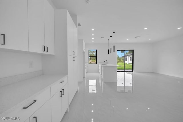 643 Knapp St, Lehigh Acres, FL 33974 - kitchen with modern cabinets, white cabinetry, recessed lighting, open floor plan, and hanging light fixtures