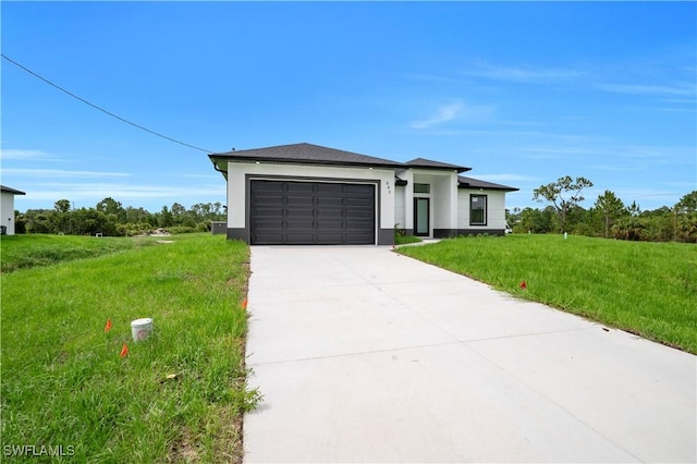643 Knapp St, Lehigh Acres, FL 33974 - prairie-style house with driveway, a garage, stucco siding, and a front lawn