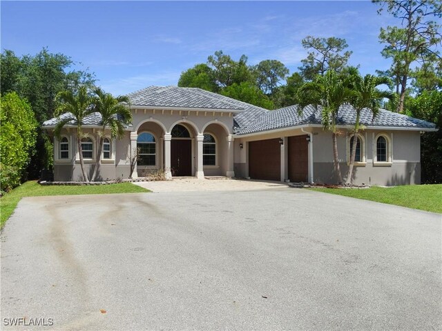 3120 68th St SW, Naples, FL 34105 - mediterranean / spanish home with stucco siding, a garage, asphalt driveway, and a front yard