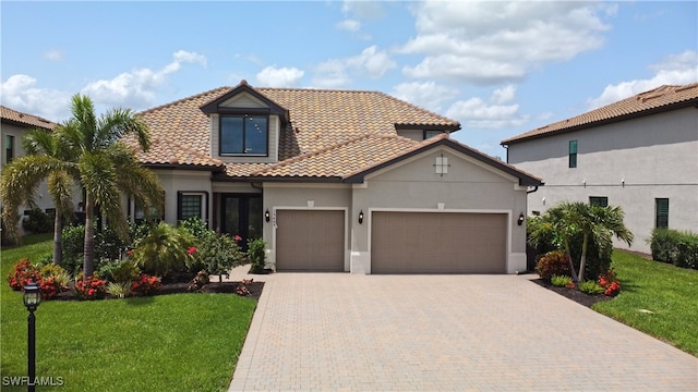 19449 The Place Blvd, Estero, FL 33928 - mediterranean / spanish-style house with an attached garage, a front yard, and stucco siding