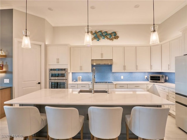 19449 The Place Blvd, Estero, FL 33928 - kitchen with appliances with stainless steel finishes, under cabinet range hood, backsplash, light countertops, and crown molding