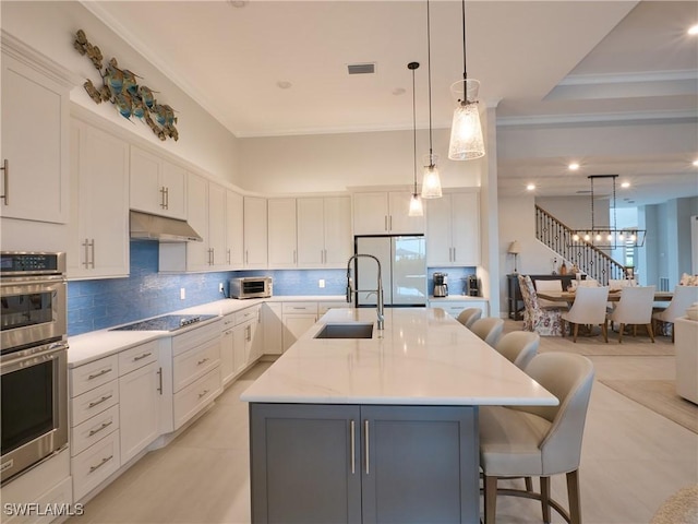 19449 The Place Blvd, Estero, FL 33928 - kitchen with freestanding refrigerator, a sink, black electric stovetop, stainless steel double oven, and decorative backsplash