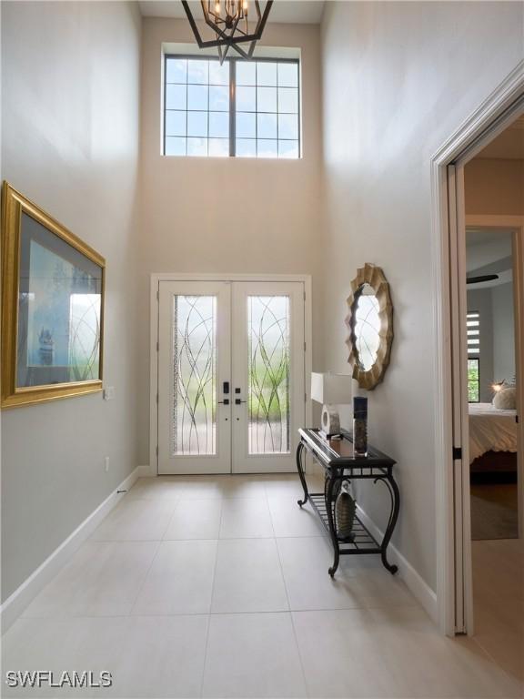 19449 The Place Blvd, Estero, FL 33928 - tiled foyer entrance with a high ceiling, french doors, healthy amount of natural light, baseboards, and a chandelier
