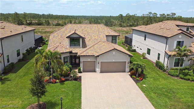 19449 The Place Blvd, Estero, FL 33928 - mediterranean / spanish house featuring an attached garage, decorative driveway, stucco siding, a tile roof, and a front yard