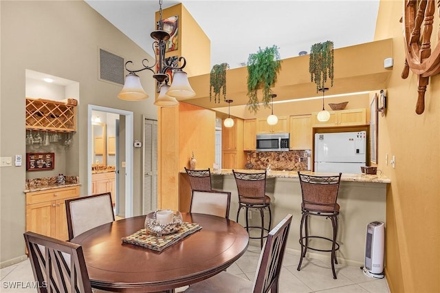 16276 Nautical Way Unit 1402, Bokeelia, FL 33922 - dining space with light tile patterned floors, high vaulted ceiling, and a chandelier