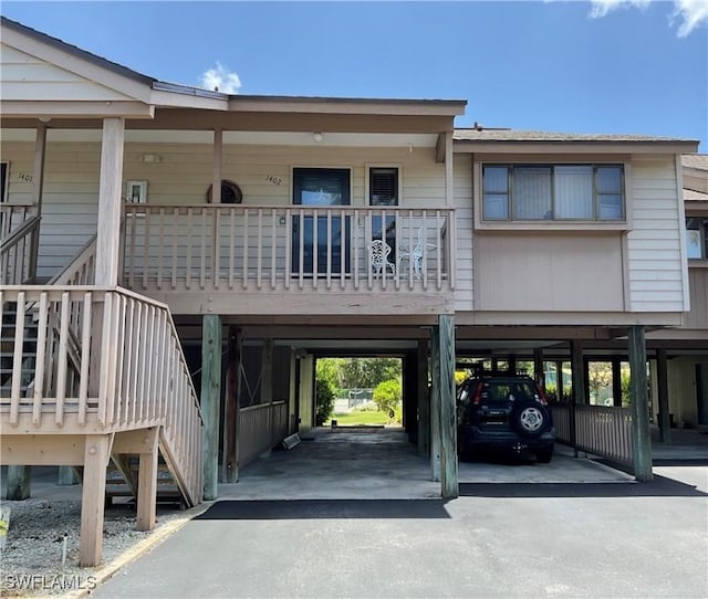 16276 Nautical Way Unit 1402, Bokeelia, FL 33922 - view of building exterior with stairway, a carport, and asphalt driveway