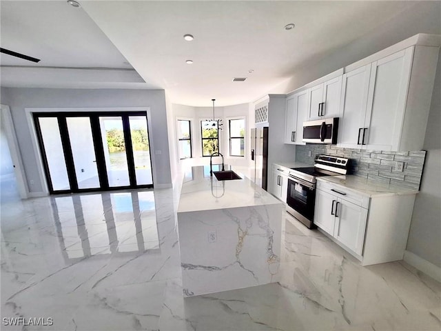 4956 30th Pl SW, Naples, FL 34116 - kitchen with stainless steel appliances, a sink, baseboards, light marble finish flooring, and decorative backsplash