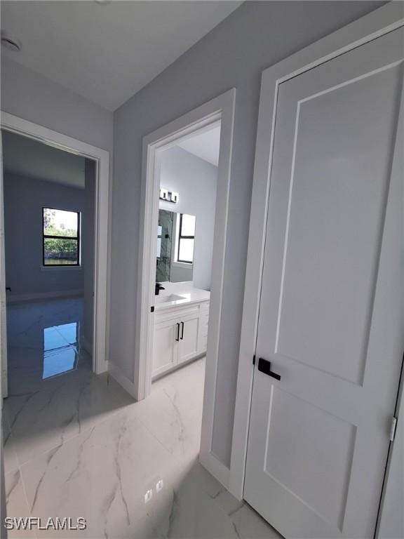 4956 30th Pl SW, Naples, FL 34116 - hallway with light marble finish flooring, a sink, and baseboards