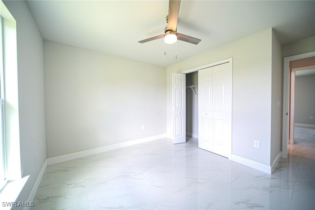 856 Chezy St E, Lehigh Acres, FL 33974 - unfurnished bedroom featuring light marble finish flooring, baseboards, a closet, and ceiling fan