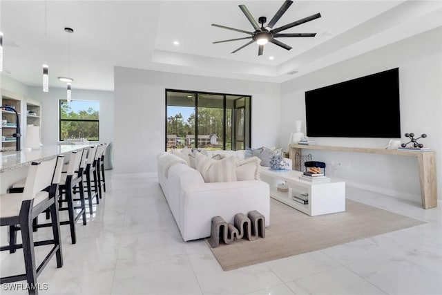 4119 43rd Ave NE, Naples, FL 34120 - living room featuring light marble finish flooring, a ceiling fan, a tray ceiling, and recessed lighting