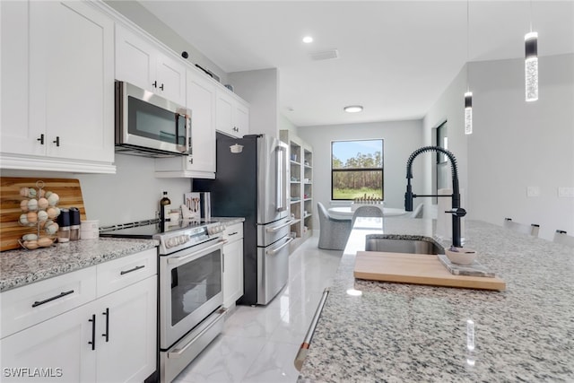 4119 43rd Ave NE, Naples, FL 34120 - kitchen featuring appliances with stainless steel finishes, white cabinetry, light stone countertops, light marble finish floors, and recessed lighting