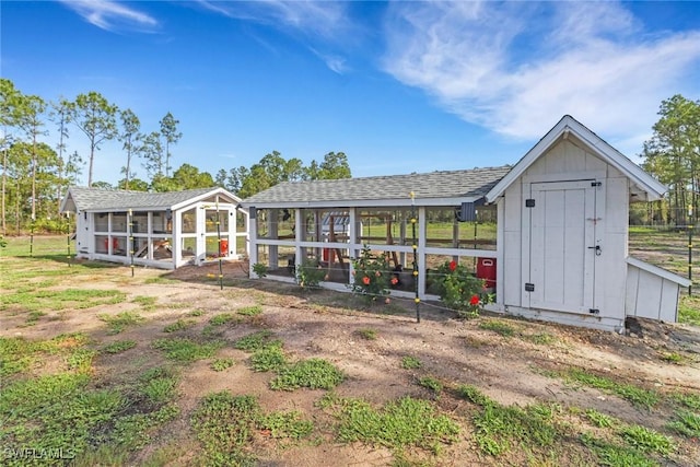4119 43rd Ave NE, Naples, FL 34120 - rear view of property featuring exterior structure, an outbuilding, board and batten siding, and roof with shingles