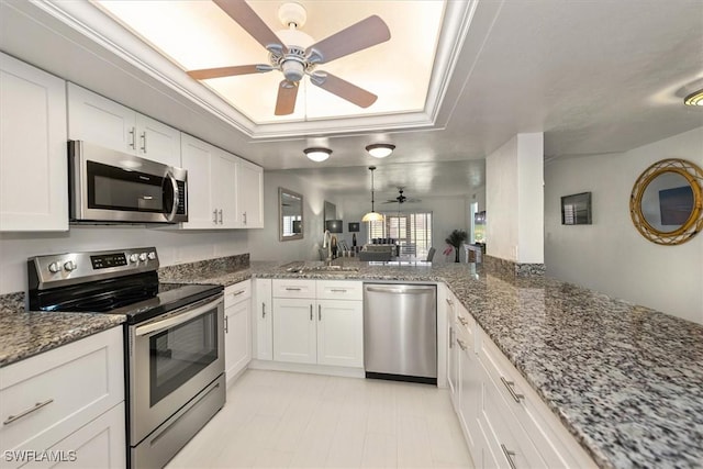 12541 Kelly Sands Way Unit 19, Fort Myers, FL 33908 - kitchen with stainless steel appliances, ceiling fan, a raised ceiling, white cabinetry, and stone counters
