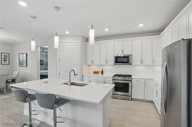 1870 Amador Ct, Naples, FL 34120 - kitchen featuring stainless steel appliances, white cabinets, a kitchen breakfast bar, light countertops, and recessed lighting