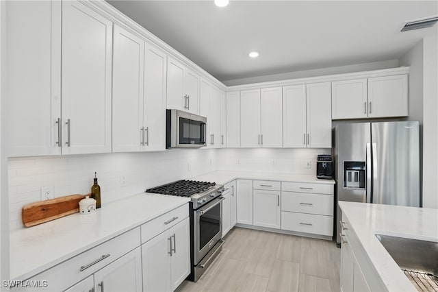 1870 Amador Ct, Naples, FL 34120 - kitchen featuring stainless steel appliances, white cabinets, backsplash, recessed lighting, and light stone counters