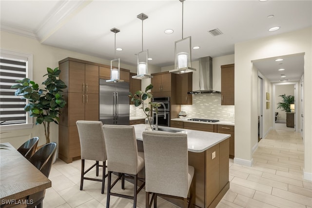 16382 Viansa Way Unit 3-202, Naples, FL 34110 - kitchen featuring wall chimney exhaust hood, appliances with stainless steel finishes, decorative backsplash, a kitchen breakfast bar, and light countertops