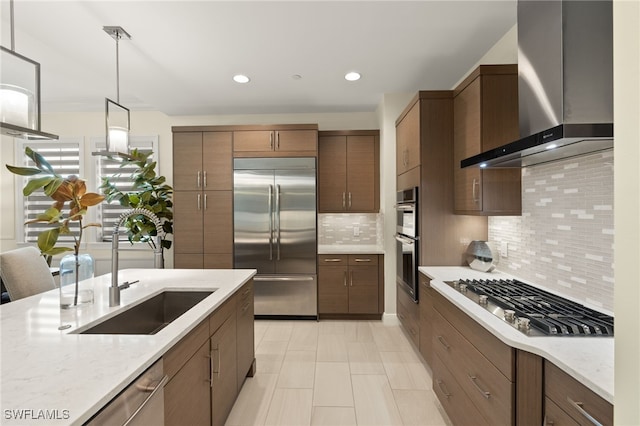 16382 Viansa Way Unit 3-202, Naples, FL 34110 - kitchen with stainless steel appliances, wall chimney exhaust hood, a sink, backsplash, and pendant lighting