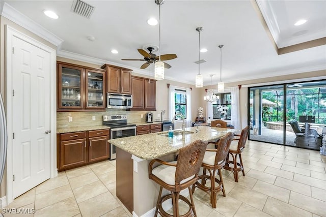 11177 Monte Carlo Blvd, Bonita Springs, FL 34135 - kitchen with stainless steel appliances, ornamental molding, a kitchen breakfast bar, ceiling fan, and healthy amount of natural light