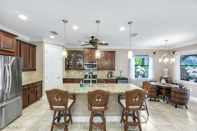 11177 Monte Carlo Blvd, Bonita Springs, FL 34135 - kitchen with appliances with stainless steel finishes, tasteful backsplash, light stone counters, a kitchen bar, and recessed lighting