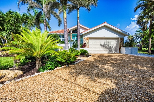 1226 Par View Dr, Sanibel, FL 33957 - view of front of property with driveway, an attached garage, and stone siding