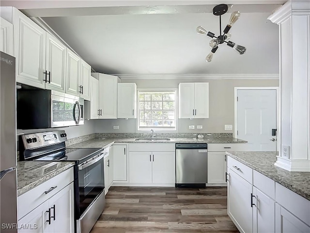 93 E Mariana Ave, North Fort Myers, FL 33917 - kitchen with stainless steel appliances, wood finished floors, white cabinets, ornamental molding, and light stone counters