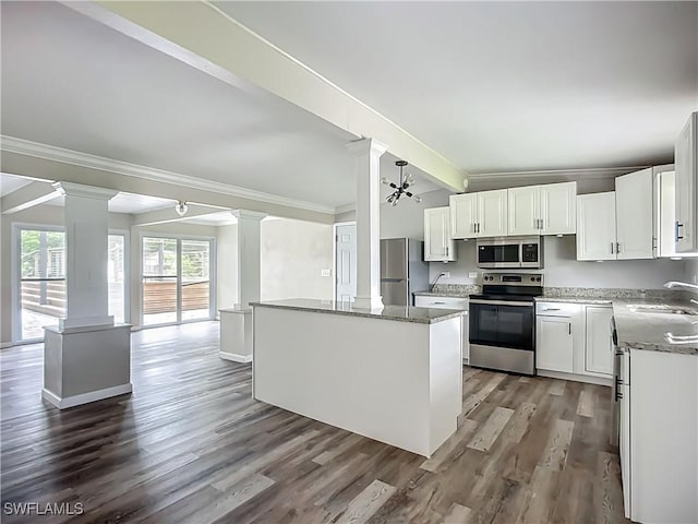 93 E Mariana Ave, North Fort Myers, FL 33917 - kitchen featuring appliances with stainless steel finishes, ornate columns, crown molding, dark wood-style floors, and a center island