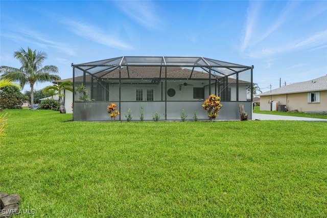 4903 Bygone St, Lehigh Acres, FL 33971 - back of property with a lawn, a lanai, and a ceiling fan
