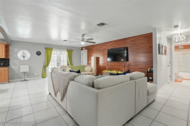 4903 Bygone St, Lehigh Acres, FL 33971 - living room featuring an accent wall, wooden walls, light tile patterned floors, and a ceiling fan