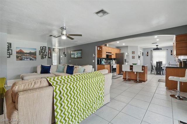 4903 Bygone St, Lehigh Acres, FL 33971 - living area with arched walkways, a ceiling fan, and light tile patterned flooring