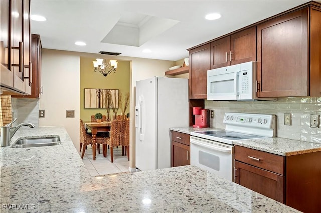 2012 SW 8th Ct, Cape Coral, FL 33991 - kitchen with white appliances, a chandelier, a sink, light stone counters, and tasteful backsplash