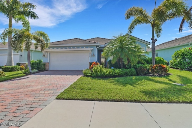 14594 Tropical Dr, Naples, FL 34114 - single story home featuring a garage, driveway, a front yard, stucco siding, and a tile roof