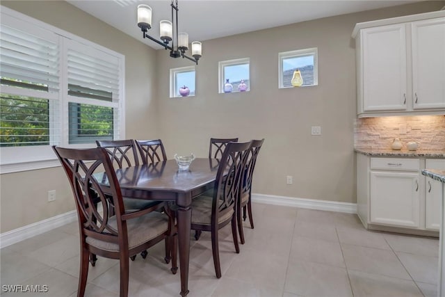 14594 Tropical Dr, Naples, FL 34114 - dining space featuring a chandelier, light tile patterned floors, and baseboards