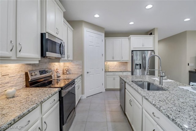 14594 Tropical Dr, Naples, FL 34114 - kitchen with stainless steel appliances, a sink, white cabinets, and recessed lighting