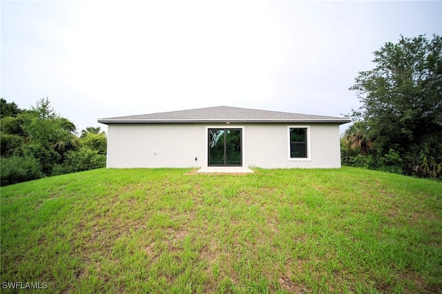 374 Pennfield St, Lehigh Acres, FL 33974 - rear view of property featuring a lawn and stucco siding