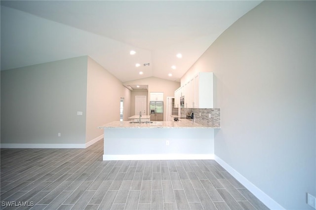 374 Pennfield St, Lehigh Acres, FL 33974 - kitchen featuring appliances with stainless steel finishes, vaulted ceiling, white cabinetry, a peninsula, and light stone countertops