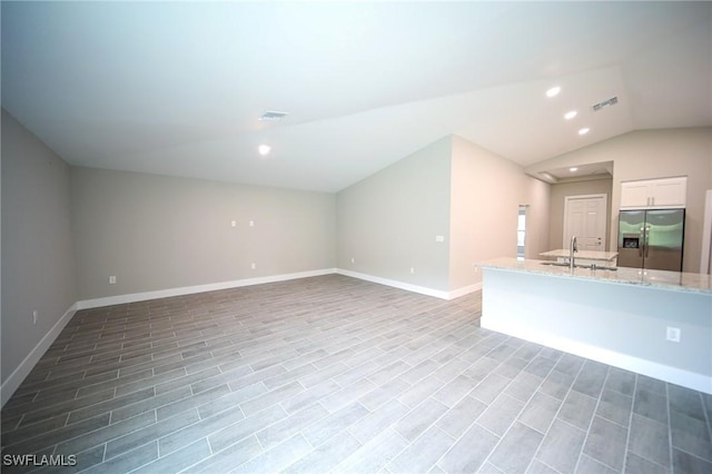 374 Pennfield St, Lehigh Acres, FL 33974 - unfurnished living room featuring vaulted ceiling, a sink, recessed lighting, and baseboards