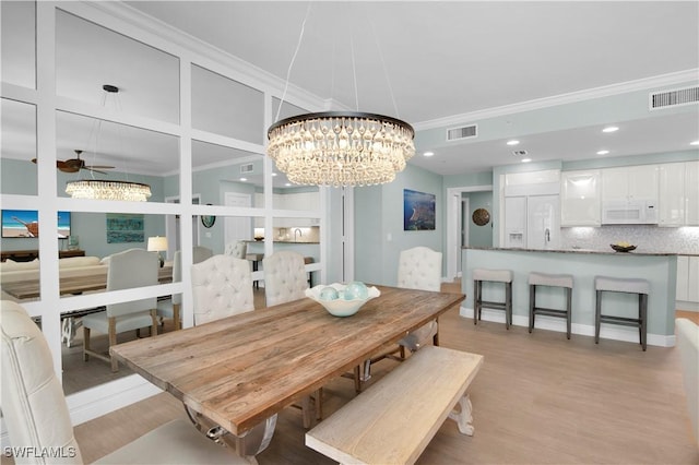 740 N Collier Blvd Unit 206, Marco Island, FL 34145 - dining room featuring a chandelier, ornamental molding, light wood-type flooring, a ceiling fan, and baseboards