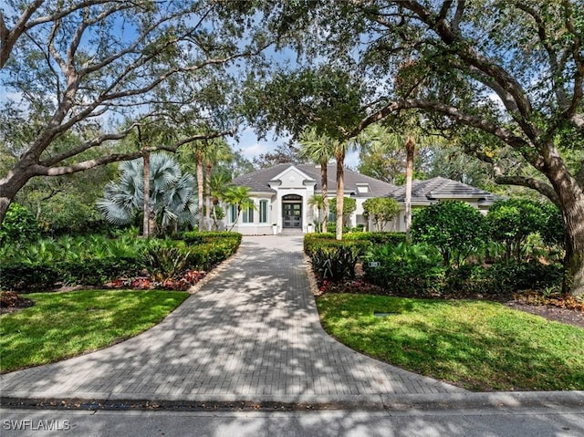 12147 Colliers Reserve Dr, Naples, FL 34110 - view of front of home with stucco siding, french doors, and a front yard