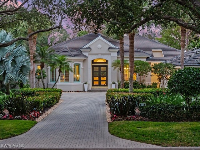 12147 Colliers Reserve Dr, Naples, FL 34110 - view of front of home with french doors, stucco siding, and a tiled roof