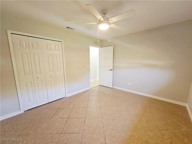 1221 SW 10th Ter, Cape Coral, FL 33991 - unfurnished bedroom featuring tile patterned floors, a closet, baseboards, and ceiling fan