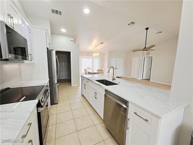 1221 SW 10th Ter, Cape Coral, FL 33991 - kitchen featuring stainless steel appliances, a sink, white cabinets, ceiling fan, and light stone counters