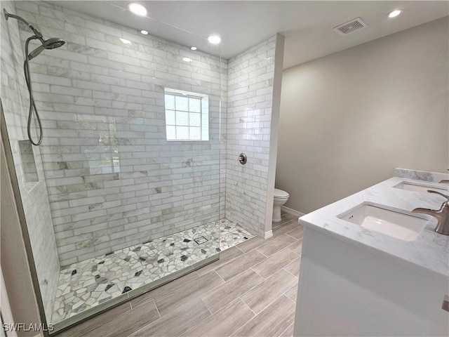 1221 SW 10th Ter, Cape Coral, FL 33991 - full bathroom with a tile shower, toilet, double vanity, recessed lighting, and baseboards